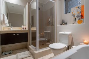 Modern bathroom with walk-in shower, oversized bathtub, vanity and luxury amenities in a Cape Town CBD apartment.