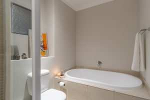 Modern bathroom with spacious bathtub, walk-in shower, luxury towels and spa-inspired design in a Cape Town CBD apartment.