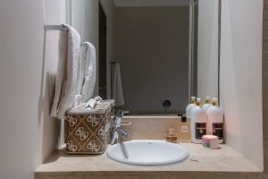 Bathroom vanity with luxury toiletries, soft towels, premium guest amenities and marble countertop in a Cape Town CBD apartment.