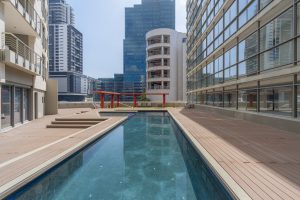 Outdoor swimming pool and children's pool on the ICON building pool deck in Cape Town CBD, surrounded by modern city architecture.